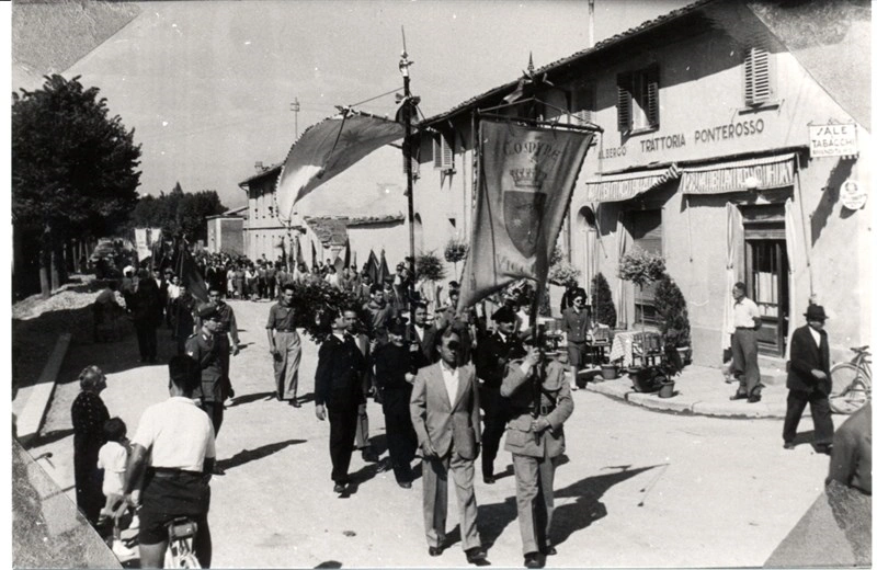 Un corteo (1954) torna in paese dopo essere stato alla Cappella dei partigiani al cimitero della Misericordia.