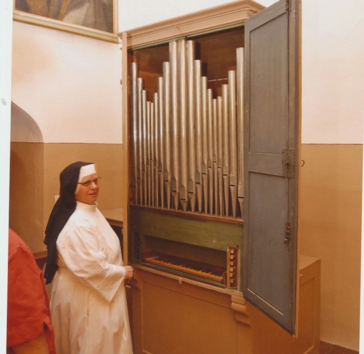 Suor Maria Imelda davanti al piccolo organo settecentesco del monastero.